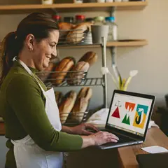 Dueña de una panadería revisa los pedidos en su computador