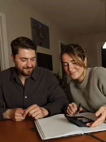 Una pareja revisa las cuentas del mes con una calculadora